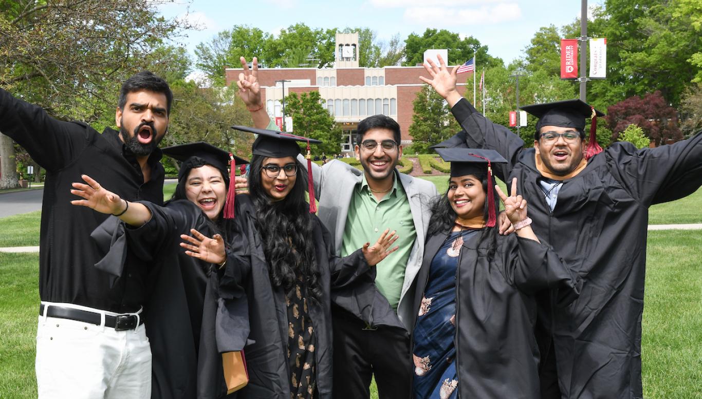 Students in Commencement attire on the Campus Mall