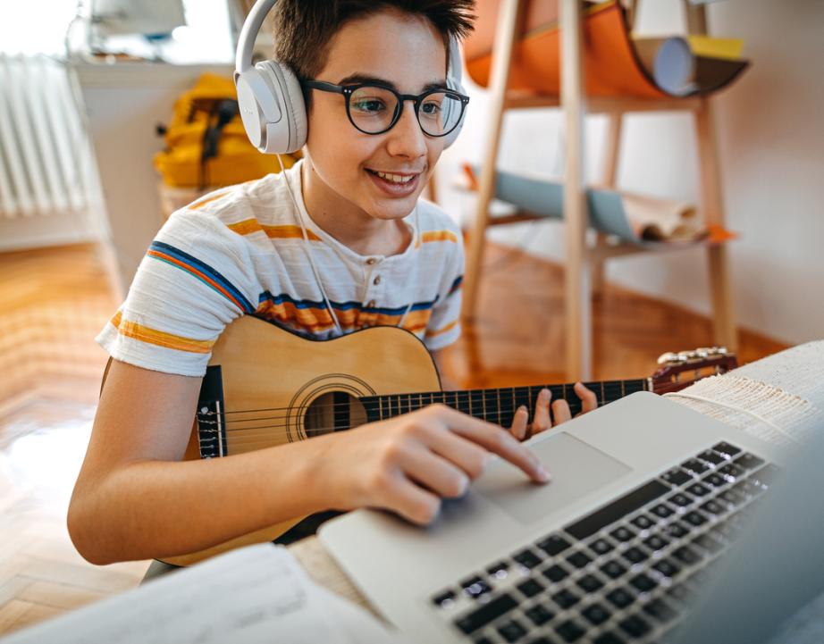 Student takes online guitar lesson