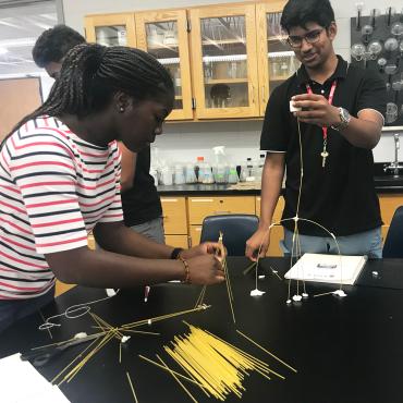 Students build structures out of marshmallows and dry spaghe