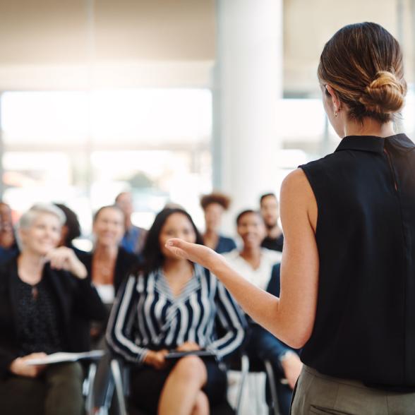 Woman speaks in front of group of people